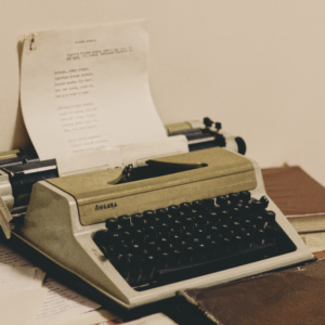 A classic typewriter with paper, surrounded by books, evokes retro vibes.
